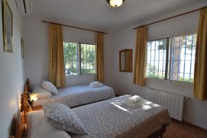 two beds in a room with two windows at Villa La Frasca with private Pool in Corumbela +42 photos