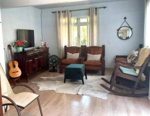 a living room with a couch and chairs and a mirror at Recanto Hellmann in Gaspar