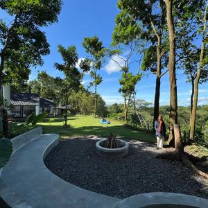 a woman walking down a path in a park at villa heve glamping in Kaliurang