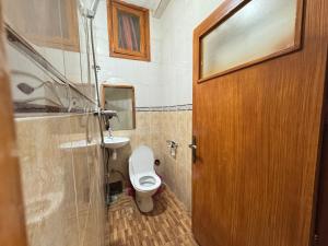 a bathroom with a toilet and a wooden door at Dar Bennis 2 in Rabat