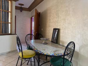 a dining room table with chairs and a vase on it at Dar Bennis 2 in Rabat