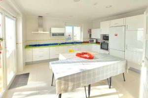 a kitchen with white cabinets and a table with a red ribbon at CASA MIGUEL y SALLY in Villanueva de las Manzanas
