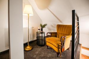 a living room with a yellow chair and a lamp at Dworek Modrzewiowy in Kraśnik