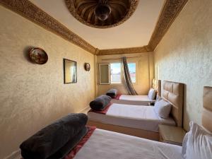 a room with four beds and a ceiling at Dar Bennis 2 in Rabat