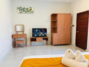 a living room with a bed and a tv at Kotoa Villa 68 in Nusa Dua