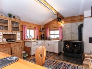 a large kitchen with wooden walls and a stove at Almhütte Bairau Kaser in Lofer