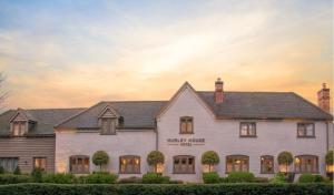 a white house with a sunset in the background at Hurley House Hotel in Hurley