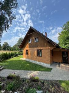 a small wooden house in a field with trees at Roubenka Liduška in Mikulovice
