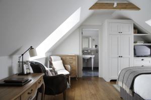 a bedroom with a bed and a desk with chairs at Hurley House Hotel in Hurley