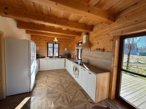a kitchen with white cabinets and a large window at Roubenka Liduška in Mikulovice