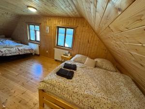 a bedroom with two beds in a wooden cabin at Roubenka Liduška in Mikulovice +40 photos