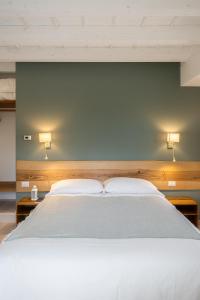 ein Schlafzimmer mit einem großen weißen Bett und zwei Kissen in der Unterkunft Cascina Bagaggera in Rovagnate