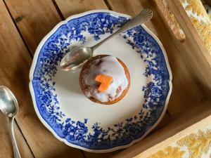 a doughnut on a blue and white plate with a spoon at Le Château de La Coste in Saint-Julien