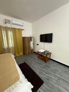 a hotel room with a bed and a flat screen tv at Patnem Bliss in Canacona