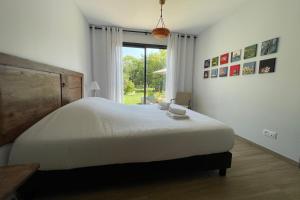 a bedroom with a large white bed and a window at Le Clos des Marmuzots parking & garden in Bayeux