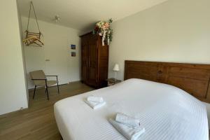 a bedroom with a white bed with two pillows on it at Le Clos des Marmuzots parking & garden in Bayeux