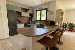 a kitchen with a large wooden table and chairs at Le Clos des Marmuzots parking & garden in Bayeux +14 photos