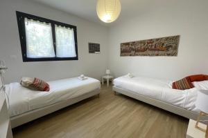 a room with two beds and a window at Le Clos des Marmuzots parking & garden in Bayeux
