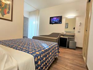 a hotel room with a bed and a television at Hotel Ornella in Lido di Jesolo