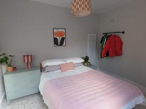a bedroom with a bed and a dresser with a pink blanket at Tranquil flat in vibrant Nether Edge in Nether Edge