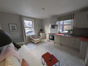 a living room with a white couch and a kitchen at Tranquil flat in vibrant Nether Edge in Nether Edge