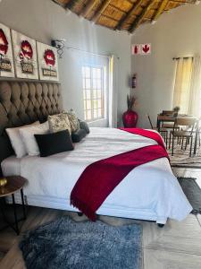 a bedroom with a large bed with a red and white blanket at Banabaka spa and venue in White River +12 photos