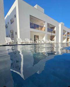 a house with a swimming pool in front of a house at Apartamento Jacumã -Conde-PB in Conde