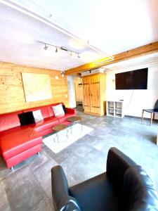 a living room with a red couch and a flat screen tv at Apartments Chalet Tatyana in Leukerbad