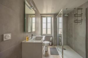 a bathroom with a sink and a toilet and a shower at Les Colibris little house in the city-center in Arromanches-les-Bains