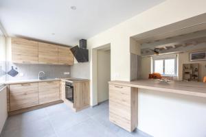 a kitchen with wooden cabinets and a counter top at Les Colibris little house in the city-center in Arromanches-les-Bains