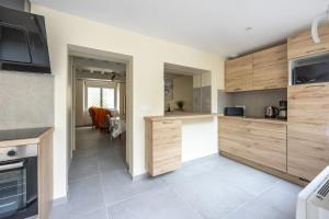 a kitchen with wooden cabinets and a dining room at Les Colibris little house in the city-center in Arromanches-les-Bains