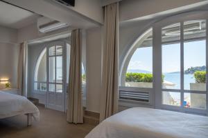 a bedroom with a view of the ocean at Nelly's Apartments in Tolo
