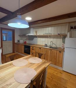 a kitchen with a wooden table and a white refrigerator at Apartmán na statku in Teplice