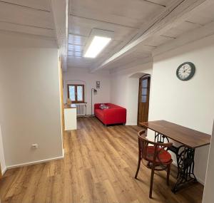a living room with a table and a red couch at Apartmán na statku in Teplice +3 photos