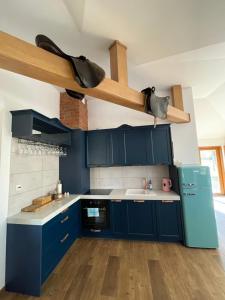 a kitchen with blue cabinets and a sink at Gajówka Pilica 45A in Łęg Ręczyński