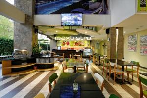 restauracja ze stołami i krzesłami oraz bar w obiekcie MaxOneHotels at Bukit Jimbaran w mieście Jimbaran