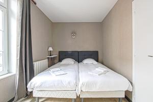 a bedroom with a bed with two towels on it at Le nid Saint Jean apartment in the heart of the city in Bayeux