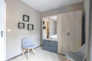 a bedroom with a vanity and two chairs and a mirror at Le nid Saint Jean apartment in the heart of the city in Bayeux