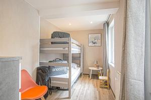 a small room with a bunk bed and a desk at Le nid Saint Jean apartment in the heart of the city in Bayeux