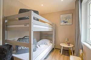 a bunk bed room with two bunk beds and a table at Le nid Saint Jean apartment in the heart of the city in Bayeux +16 photos