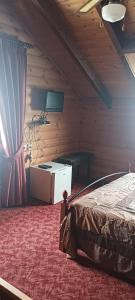 a bedroom with a bed and a desk and a curtain at mezonetaki in Karpenisi