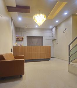 a waiting room with a podium and a couch in a room at Hotel Royal Residency Executive in Miraj