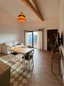 a living room with a table and a couch at Esprit Lubéron, Le Romarin, logement entier in Le Thor