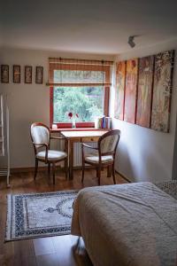 a bedroom with a table and chairs and a window at Feel-Harmonia w Nowym Kawkowie in Nowe Kawkowo