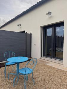 a blue table and two chairs on a patio at Esprit Lubéron, Le Romarin, logement entier in Le Thor +1 photo