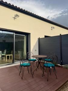 a patio with a table and chairs on a deck at Esprit Lubéron, Le Romarin, logement entier in Le Thor