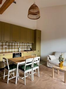 a kitchen with a wooden table and chairs at Esprit Lubéron, Le Romarin, logement entier in Le Thor