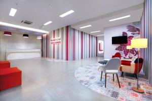 a lobby with a waiting room with a table and chairs at favehotel Sudirman Bojonegoro in Bojonegoro