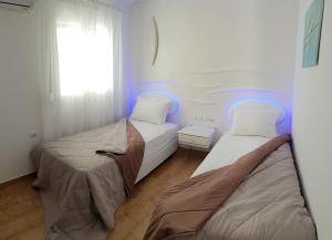 two beds in a small room with blue lights at Beachfront villa Ioanna in Kokkari