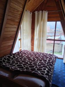 a bed in a room with a large window at Casa de campo y Chalet las Morenas in Sicuani